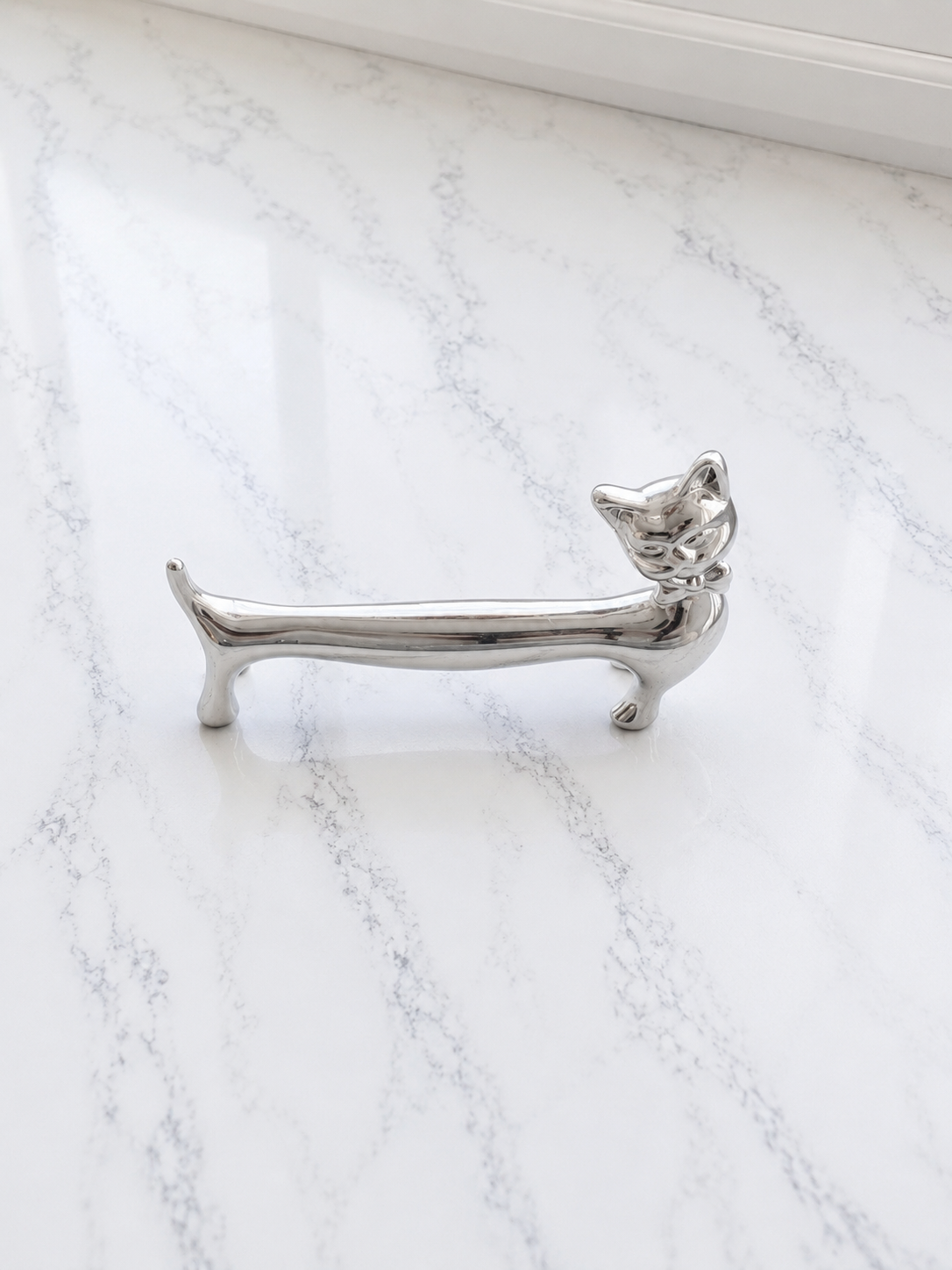 Smörtax som katt i polerad metall på marmor